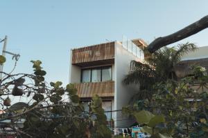 奥尔沃克斯岛Casa Peregrino Holbox的带阳台和棕榈树的建筑