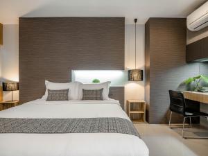 清迈奈普费斯特酒店的一间卧室配有一张大床和一张书桌