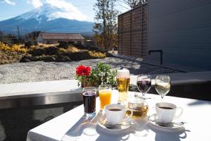 富士河口湖Fujikawaguchiko Resort Hotel的阳台上的桌子上摆放着葡萄酒和饮料