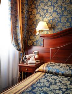 罗马罗马最佳酒店的一间卧室配有一张床和一张带台灯的桌子