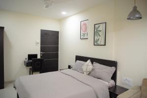 孟买Lite Stays - Vile Parle East的卧室配有白色的床和书桌