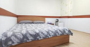 扶余Healinghouse Peakjang的一间卧室配有一张带木制床头板的床