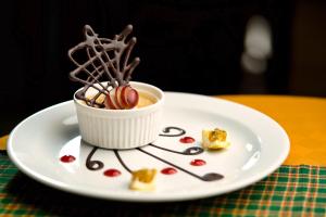 阿鲁沙Kibo Palace Hotel Arusha的白盘,桌上有一杯甜点