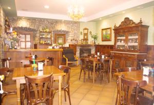 比利亚维西奥萨Hotel Palacio Carlos I的餐厅设有木桌、椅子和壁炉