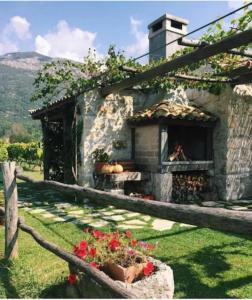 格鲁达Vineyard Eco Cottage near Dubrovnik的庭院内带壁炉的石头房子