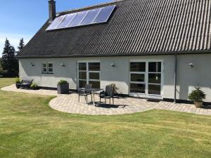 普赖斯特Søfryd B&B的房屋设有太阳能屋顶,配有桌椅