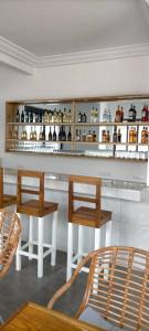 洛美Hôtel Marbella的酒吧配有两把椅子和带瓶子的吧台
