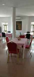 洛美Hôtel Marbella的用餐室配有粉红色的桌子和椅子