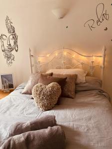 伦敦Stunning, peaceful entire flat in the centre of Wimbledon的一张带心枕和灯的床