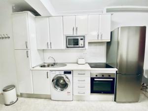 内尔哈EDIFICIO CHAPARIL的厨房配有白色橱柜和洗衣机。