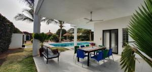 恩加帕鲁La Maison Blanche à Ngaparou, splendide villa contemporaine的一个带桌椅的庭院和一个游泳池