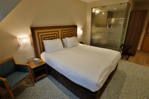 拉夫堡阔恩农庄酒店的卧室配有一张白色大床和一把椅子