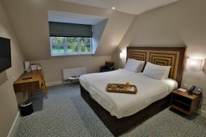 拉夫堡阔恩农庄酒店的一间卧室配有一张大床,上面有托盘