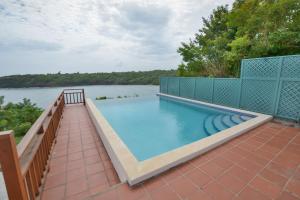 CrochuTwo Bays Beach Villa, Apartment, and Studios的享有水景的庭院内的游泳池