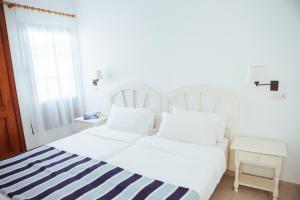 卡门港蓝色海洋海滩公寓式酒店的白色的床和蓝色及白色条纹毯子