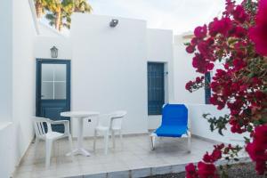 卡门港蓝色海洋海滩公寓式酒店的庭院配有桌椅和鲜花