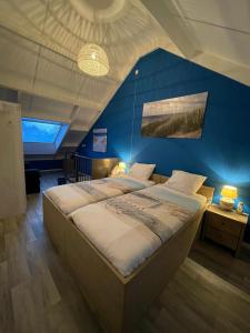 弗劳温普尔德Lise's Place的一间卧室设有一张蓝色墙壁的大床