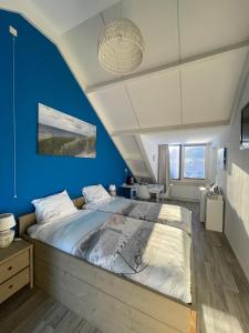 弗劳温普尔德Lise's Place的一间拥有蓝色墙壁和一张大床的卧室