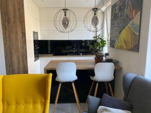 科宁Apartament Centrum- Art&Design的厨房配有2把黄色椅子和台面