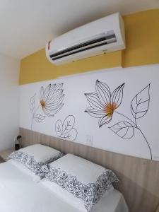 特雷西纳Smart Residence Flat - FLAT 605的一间卧室,墙上挂着鲜花