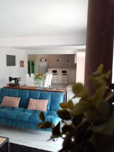 曼瓜尔迪Casa do soito的一间带蓝色沙发的客厅和一间厨房