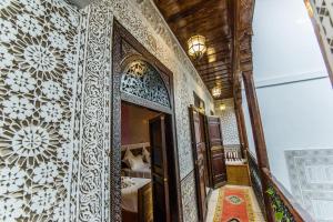 马拉喀什Riad Atlas Mejbar的走廊上设有镜子,房间设有床