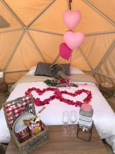麦德林Glamping La Montaña Sagrada的一张带气球的床和两篮食物及饮料