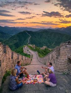 北京北京遇花园休闲度假民宿的一群人围坐在大墙上的野餐