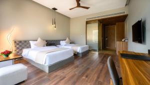 纳西克Aria Resort & Spa - Pure Veg的酒店客房设有两张床和电视。