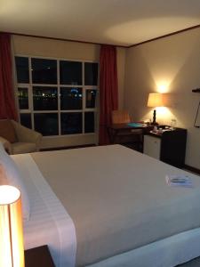 麦克坦Cebu Dulcinea Hotel and Suites-MACTAN AIRPORT HOTEL的一间设有大床和窗户的酒店客房