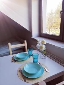 克拉科夫Prokocim Apartments的一张桌子,上面有盘子和玻璃杯,还有窗户