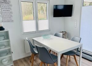 沙博伊茨Beach Chalet SunHus - modernes Chalet in Ostseenähe的窗户客房内的白色桌椅