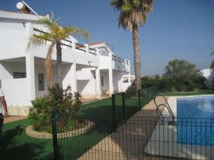科尼尔-德拉弗龙特拉Apartamentos Los Olivos的白色的房子,设有游泳池和棕榈树