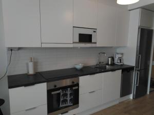 于韦斯屈莱Lutakko Apartment 2 with free car parking的厨房配有白色橱柜、水槽和炉灶。