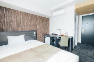 御殿场市富士山御殿场宽乐酒店(Hotel Kan-Raku Fujisan Gotemba)的一间卧室配有一张床和一张书桌