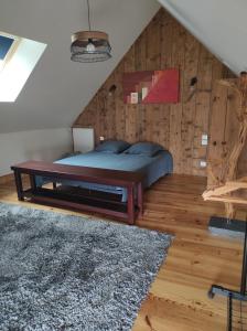 BrettevilleLa Petite Roupie的一间卧室设有一张床和木墙