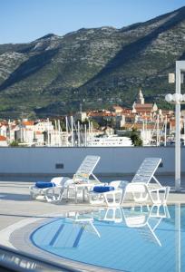 科尔丘拉Marko Polo Hotel by Aminess的一组椅子和一个屋顶游泳池