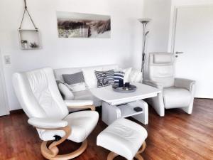 萨斯尼茨Ferienwohnung Wellenreiter的客厅配有白色家具和桌椅