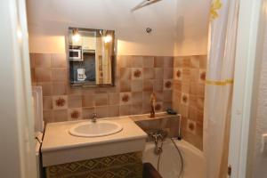 滨海阿热莱斯Agréable T2 climatisé的浴室配有盥洗盆、镜子和浴缸