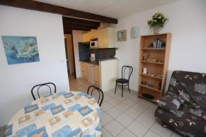 滨海阿热莱斯Agréable T2 climatisé的厨房以及带桌椅的起居室。