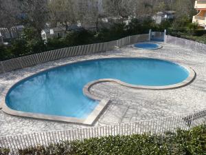滨海阿热莱斯Agréable T2 climatisé的一座大型游泳池,四周环绕着石头人行道