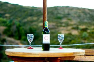 瓜塔维塔Glamping Bella Vista的桌子上放有一瓶葡萄酒和两杯酒