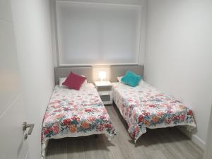 大加那利岛拉斯帕尔马斯Guanarteme Vista Surf的两张睡床彼此相邻,位于一个房间里