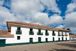 CucunubáCasa La Bisbal的白色的建筑,有红色的屋顶
