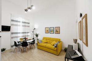 锡拉库扎Les Amis的客厅配有黄色的沙发和桌子