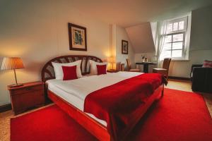 特拉本特拉巴赫Landgasthaus am Ufer的一间卧室配有一张带红色毯子的大床