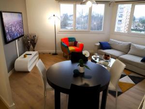 波城Appartement tout confort 2 chbres - 72m2 - avec terrasse et vue Pyrénées的客厅配有桌子和沙发