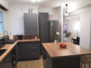 波城Appartement tout confort 2 chbres - 72m2 - avec terrasse et vue Pyrénées的厨房配有黑色橱柜和一碗水果放在桌子上