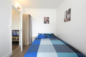 新城拉加雷讷Charmant 2 pièces proche de Paris的一间位于客房内的卧室,配有蓝色和白色的床