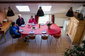 霍尔斯贝克Hageland Vakantieverblijf的一群人坐在一张红桌旁